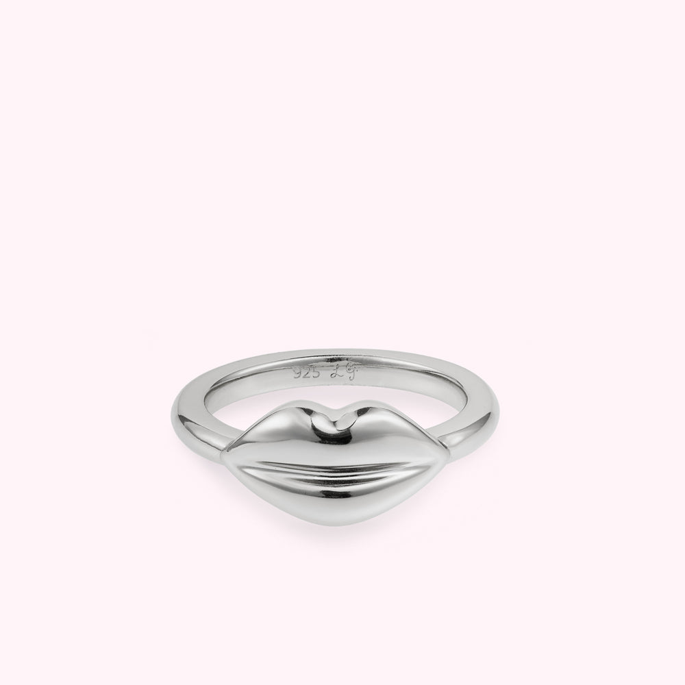 Front on image of a silver lip shape ring flat on a white background.