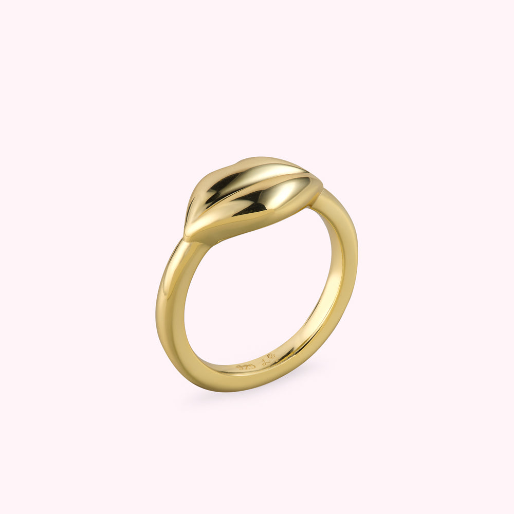 Angle side image of a gold lip shape ring on a white background.