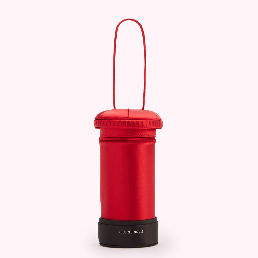 Red satin Lulu Guinness postbox-shaped handbag with black base.
