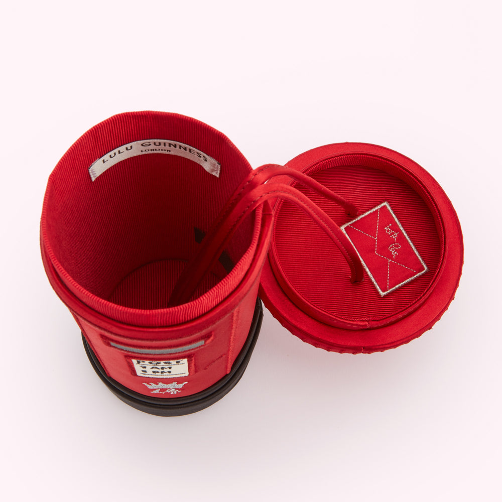 Red Lulu Guinness Post Box handbag open to reveal a embroidered letter in the interior of the lid.