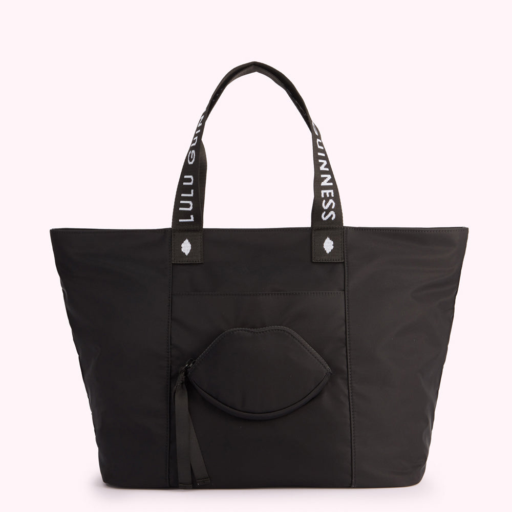 Black tote bag with "Lulu Guinness" on straps and a lip-shaped pocket.