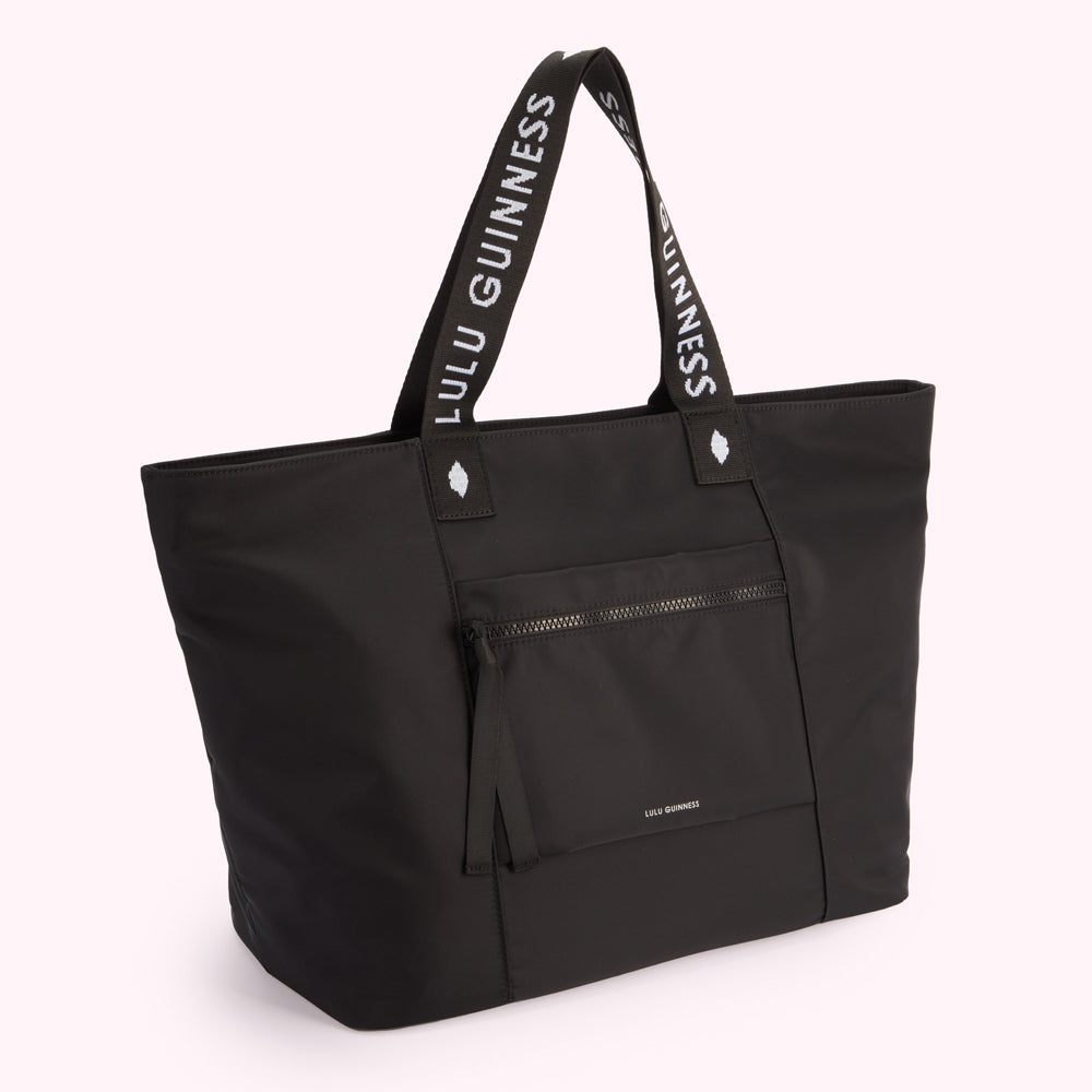 Black Lulu Guinness tote bag with white logo on straps.