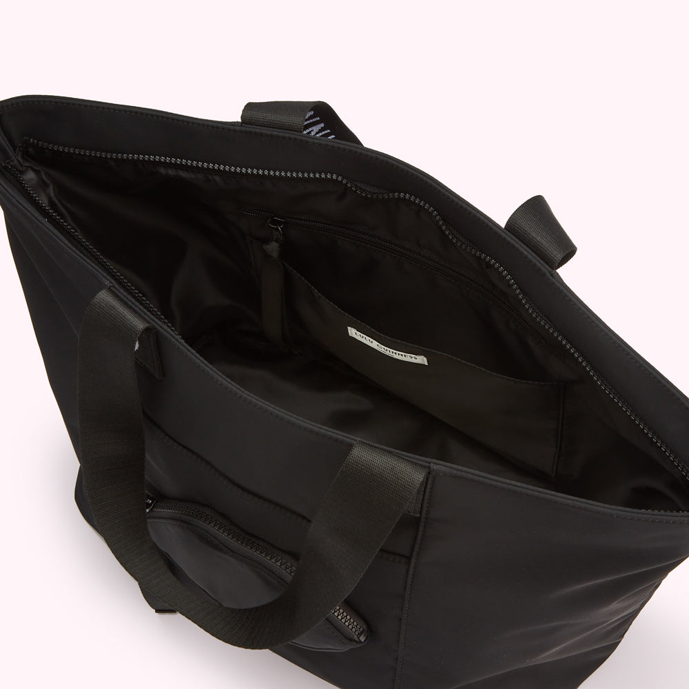 Overhead view of a black Lulu Guinness tote bag with multiple compartments open, showcasing its interior organization and design details.
