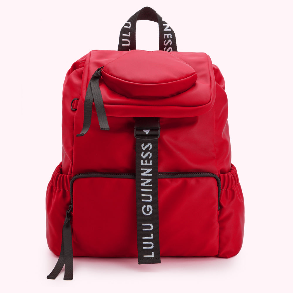 Red Lulu Guinness backpack with black straps and logo.