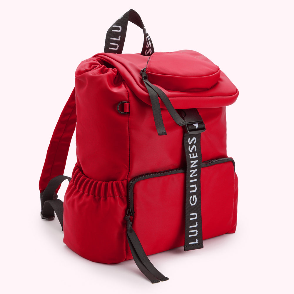 Red Lulu Guinness backpack with black logo straps.