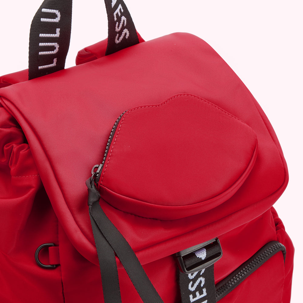 Close-up of a red backpack with a lip-shaped pocket and black accents.