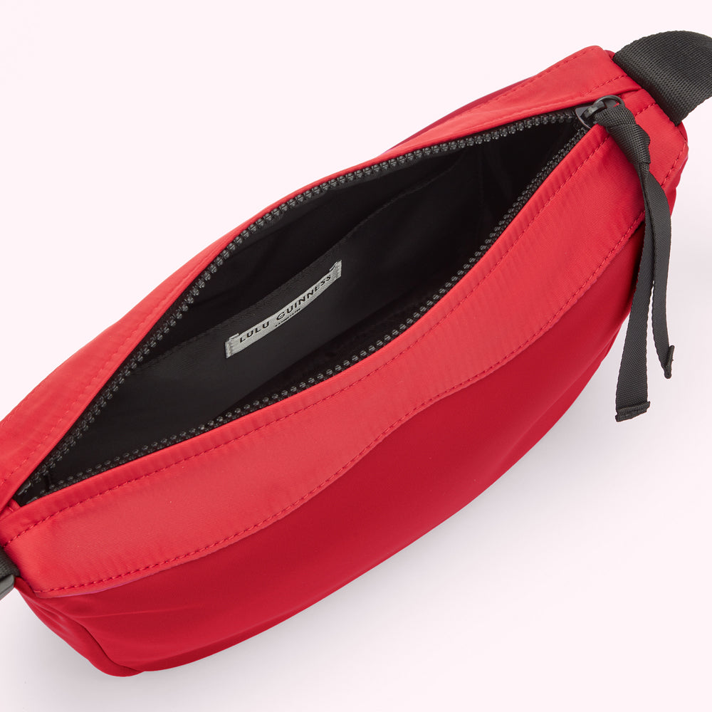 Interior of a red and black Lulu Guinness nylon shoulder bag.