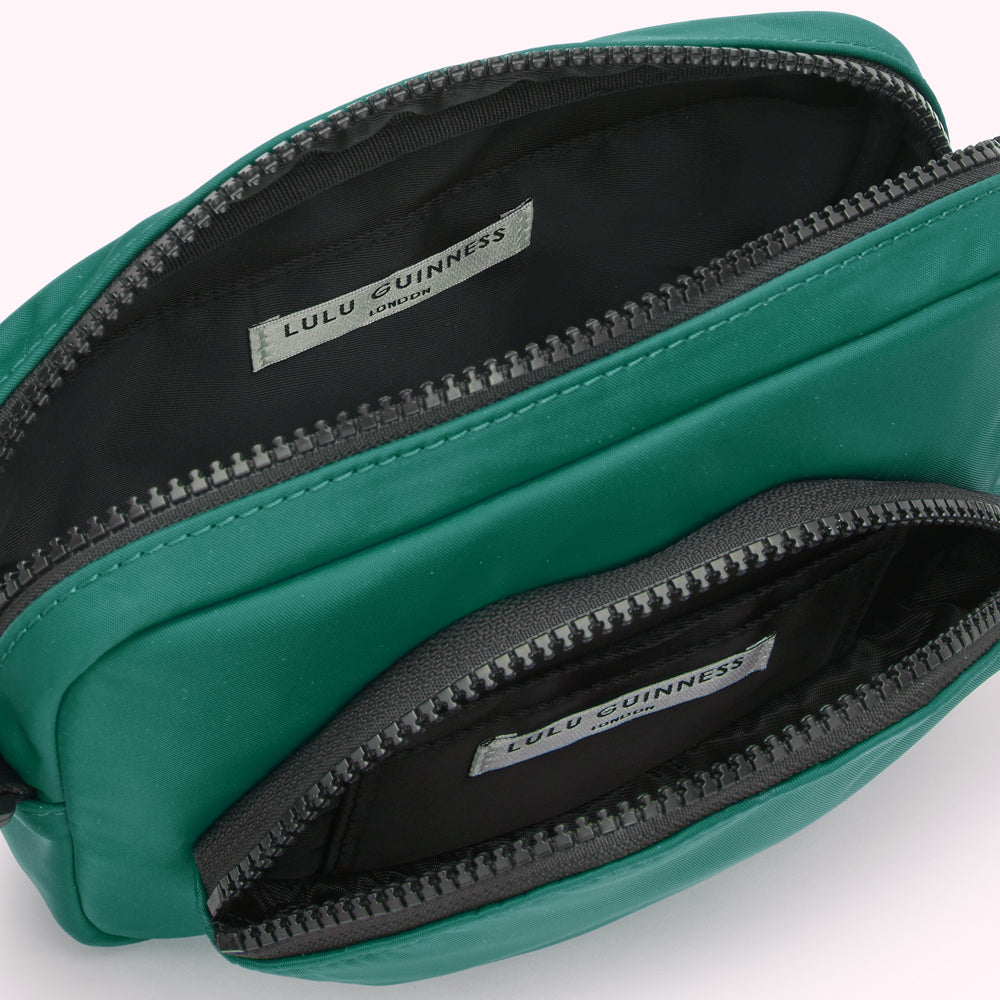 Green Lulu Guinness crossbody bag open to show interior compartments and brand label.