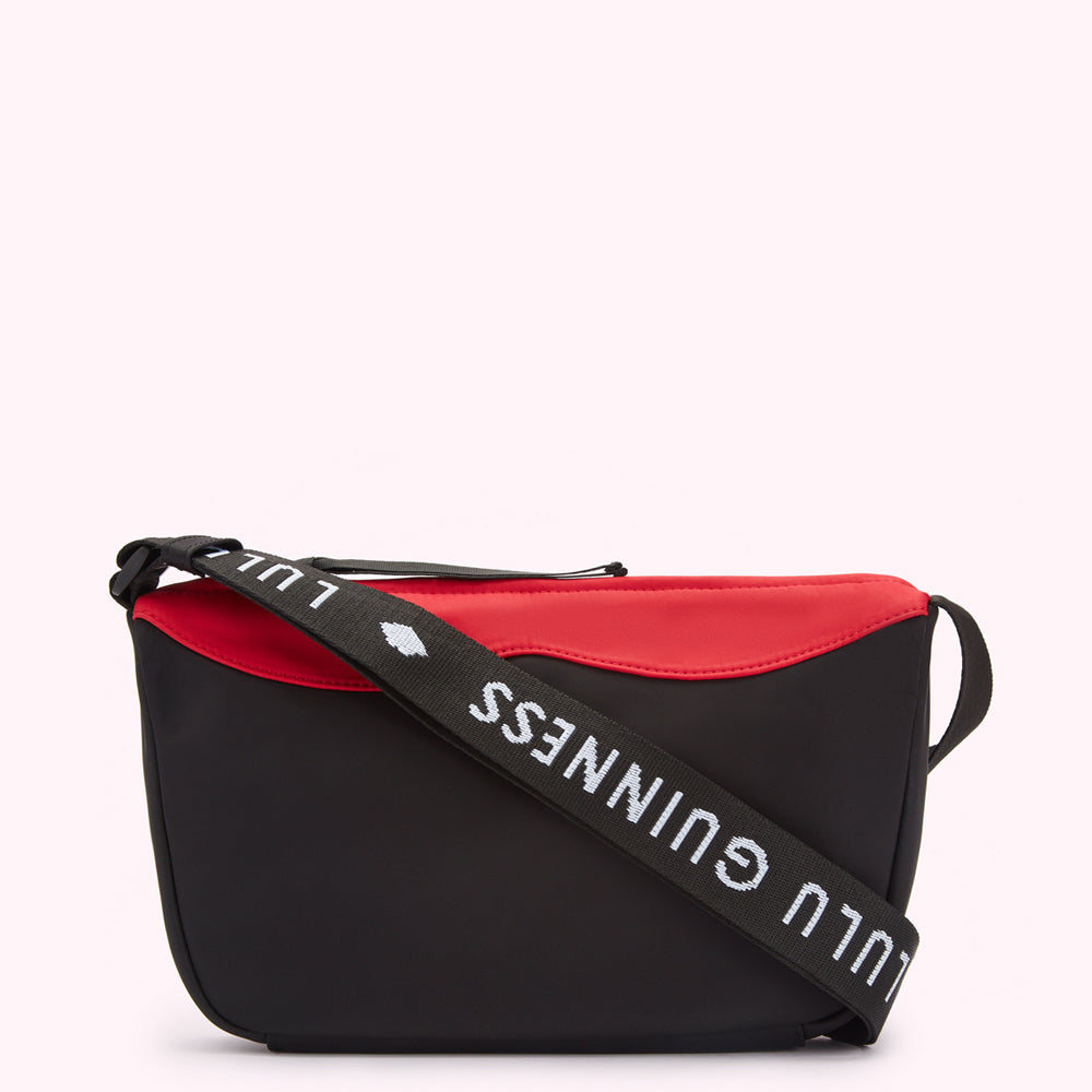 Black and red crossbody bag with "Lulu Guinness" printed on the strap.
