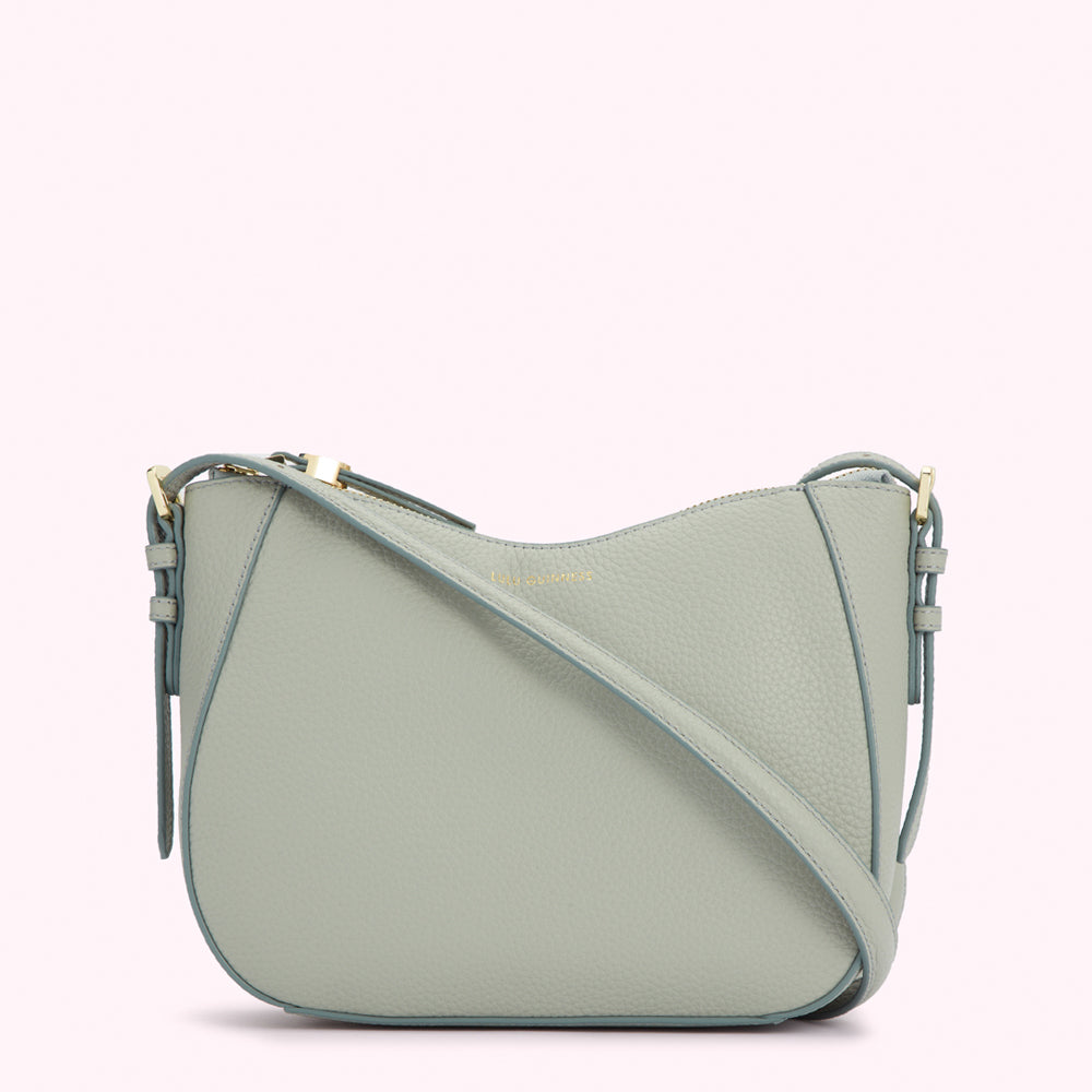 Light sage green crossbody bag with gold zipper and hardware.
