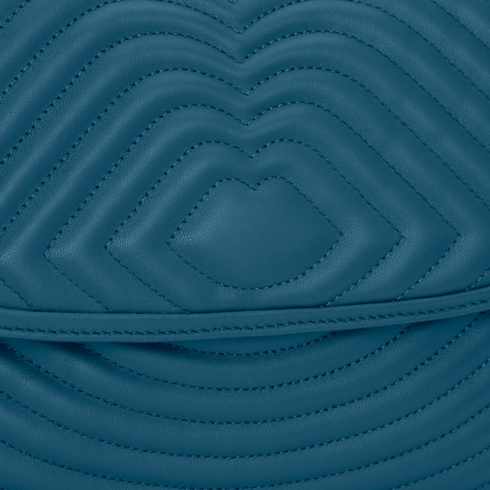 Close-up of teal quilted leather with a subtle heart pattern.
