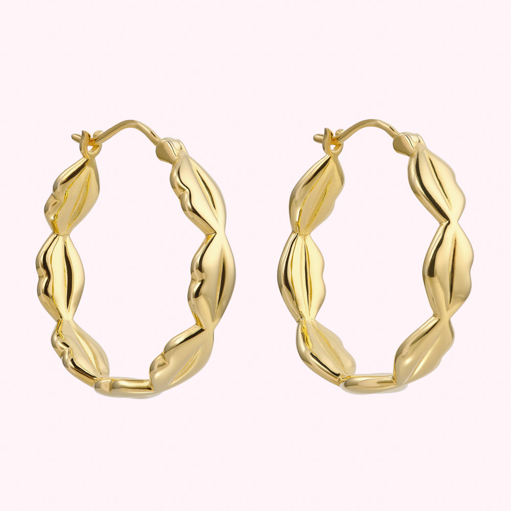 Pair of gold hoop earrings with a textured, leaf-like design.
