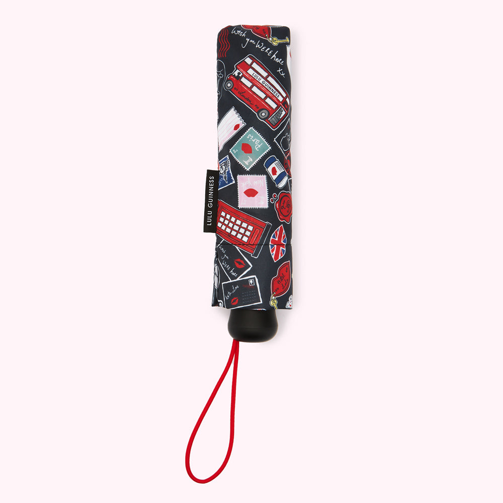 Compact Lulu Guinness umbrella with a navy background and red and white illustrations of London landmarks and romantic motifs.