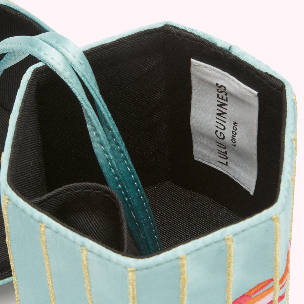 Close-up of a light blue Lulu Guinness box with gold stripes and a satin strap, the inside shows a black fabric lining and a white label reading "Lulu Guinness London".