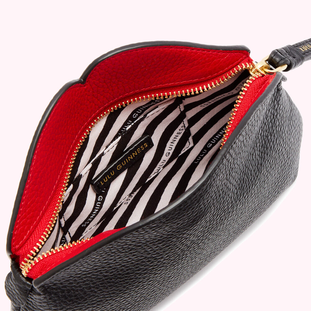 Open black Lulu Guinness purse with red interior and gold zipper.