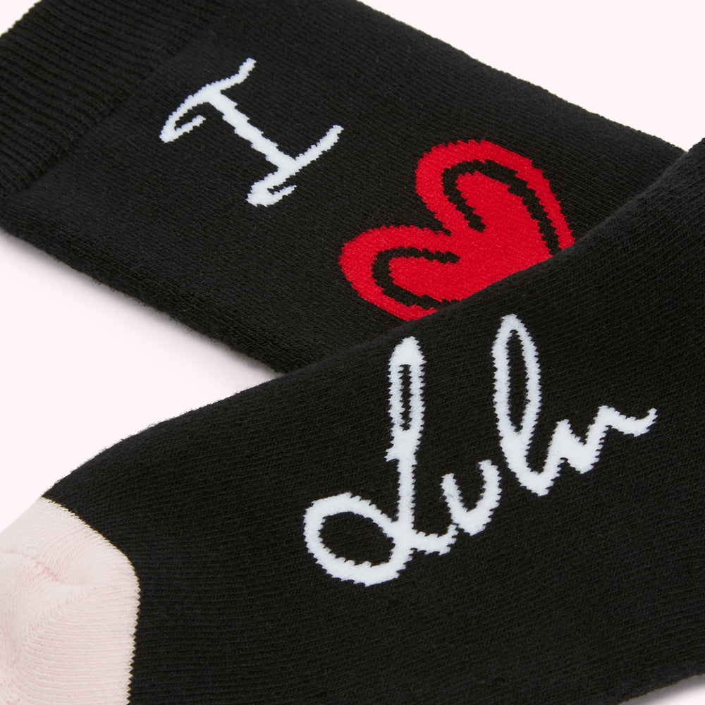 Close-up of a pair of black socks with white "I love Lulu" text and a red heart graphic.