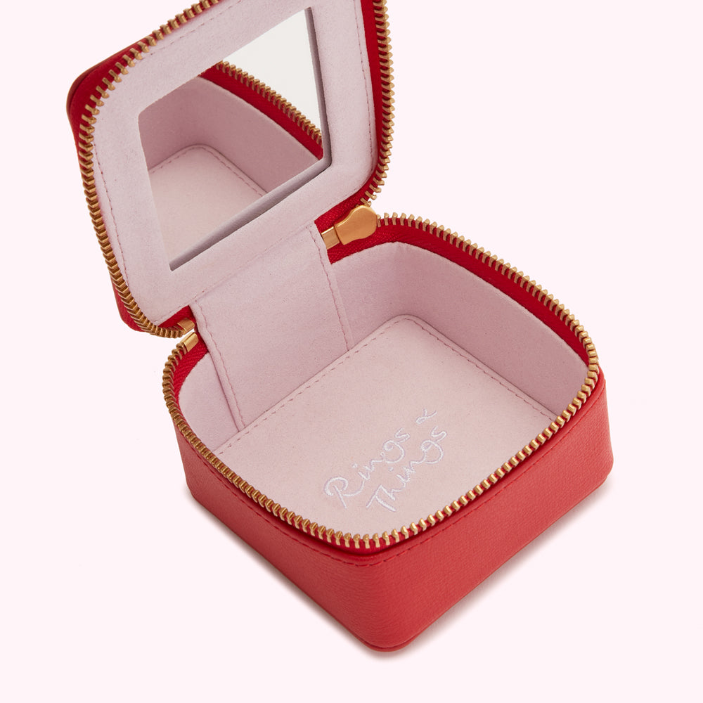 Red leather jewelry box with a pink interior and a small mirror; the words "Rings & Things" are subtly printed inside.
