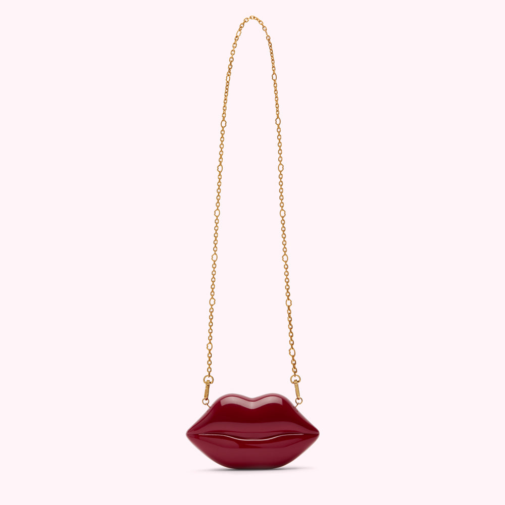 Red lip-shaped clutch with a gold chain strap.
